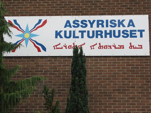 Na ceglanej ścianie tablica z napisem Assyriska Kulturhuset